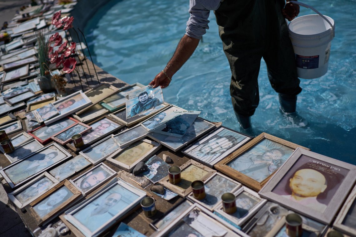 A worker picks up a photo of Staff Sgt. Matan Vinogradov who was killed in combat in 2024 after it fell into a fountain decorated with photos of victims of the Hamas attacks and soldiers who died in the war at Dizengoff Square in central Tel Aviv, Thursday, Oct. 22, 2026. (AP Photo/David Goldman) A worker picks up a photo of Staff Sgt. Matan Vinogradov who was killed in combat in 2024 after it fell into a fountain decorated with photos of victims of the Hamas attacks and soldiers who died in the war at Dizengoff Square in central Tel Aviv, Thursday, Oct. 22, 2026. (AP Photo/David Goldman)