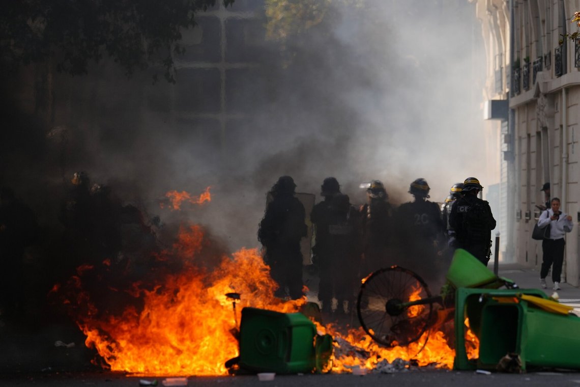 Opprørspoliti betrakter brennende søppelkasser i Paris. Foto: Aurelien Morissard / AP / NTB Opprørspoliti betrakter brennende søppelkasser i Paris. Foto: Aurelien Morissard / AP / NTB