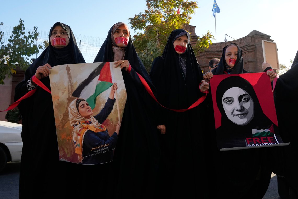 Demonstrators, mouths taped closed, hold portraits of Mahdieh Esfandiari, an Iranian national detained in France, during a protest in front of the French Embassy in Tehran to demand her release, Iran, Tuesday, Oct. 21, 2025. (AP Photo/Vahid Salemi) Demonstrators, mouths taped closed, hold portraits of Mahdieh Esfandiari, an Iranian national detained in France, during a protest in front of the French Embassy in Tehran to demand her release, Iran, Tuesday, Oct. 21, 2025. (AP Photo/Vahid Salemi)