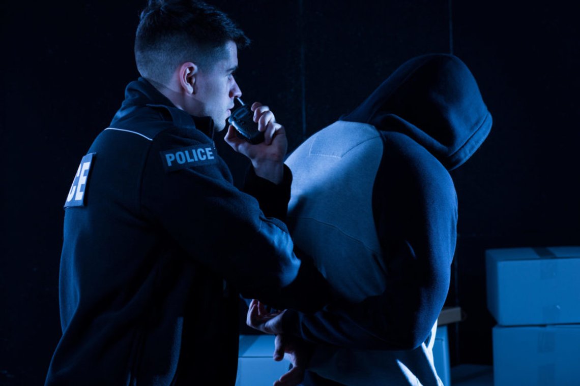 Mature policeman arresting law-breaker at night Mature policeman arresting law-breaker at night