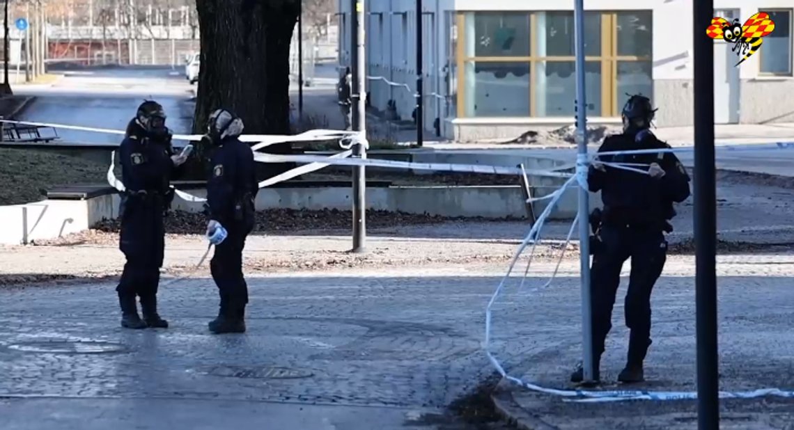 Poliser iförda skyddsmasker spärrar av området runt Säpos högkvarter i Solna. Foto: Skärmdump video Expressen Poliser iförda skyddsmasker spärrar av området runt Säpos högkvarter i Solna. Foto: Skärmdump video Expressen