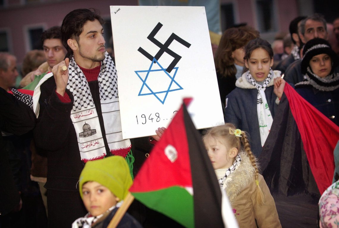 Demonstranter med två symboler - stjärna (judendom) och hakkors (Nazizme) - på samma affisch, under en pro-palestinsk demonstration i Oslo. Foto: Heiko Junge / NTB Demonstranter med två symboler - stjärna (judendom) och hakkors (Nazizme) - på samma affisch, under en pro-palestinsk demonstration i Oslo. Foto: Heiko Junge / NTB