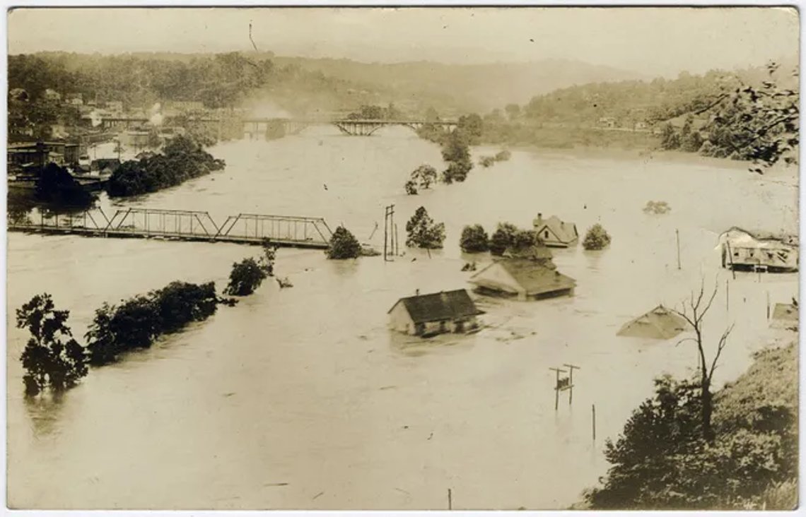 Den stora översvämningen 1916. Vykort från den västra stranden av den franska Broad River som ser söderut mot Smith Bridge och West Asheville Bridge under översvämningen i juli 1916. Smith Bridge spolades senare bort under översvämningen. Hus i West Asheville i förgrunden. Foto: Public domain, Pack Memorial Public Library, Asheville, North Carolina. Den stora översvämningen 1916. Vykort från den västra stranden av den franska Broad River som ser söderut mot Smith Bridge och West Asheville Bridge under översvämningen i juli 1916. Smith Bridge spolades senare bort under översvämningen. Hus i West Asheville i förgrunden. Foto: Public domain, Pack Memorial Public Library, Asheville, North Carolina.