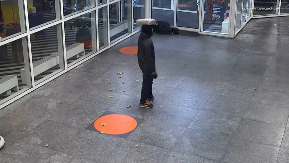En mörkhyad man ser sig omkring innan han slår den sovande mannen i huvudet med en stor sten. Stillbild från YouTube från attacken i Rotterdam. En mörkhyad man ser sig omkring innan han slår den sovande mannen i huvudet med en stor sten. Stillbild från YouTube från attacken i Rotterdam.
