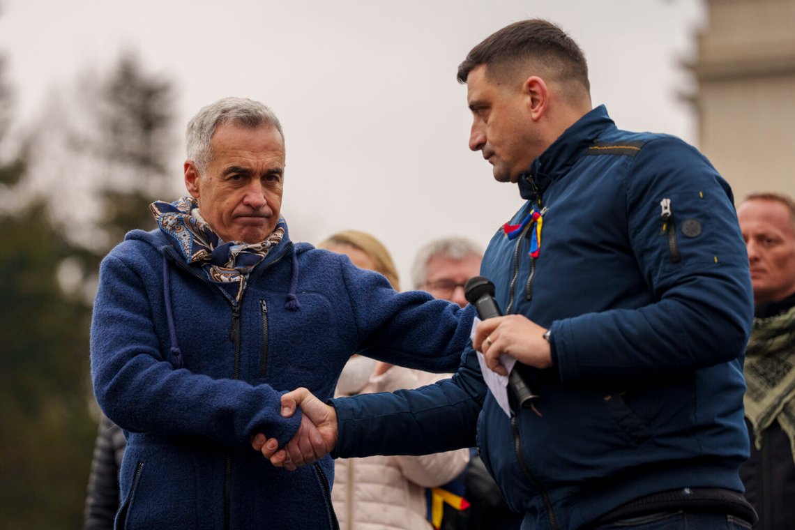 Călin Georgescu, vinnaren av den första omgången av presidentvalet – som senare ogiltigförklarades av författningsdomstolen – skakar hand med George Simion, ledaren för det högerorienterade partiet Alliance for the Unity of Romanians (AUR), under en protest utanför regeringskontoret i Bukarest, Rumänien, den 1 mars 2025. Călin Georgescu, vinnaren av den första omgången av presidentvalet – som senare ogiltigförklarades av författningsdomstolen – skakar hand med George Simion, ledaren för det högerorienterade partiet Alliance for the Unity of Romanians (AUR), under en protest utanför regeringskontoret i Bukarest, Rumänien, den 1 mars 2025.