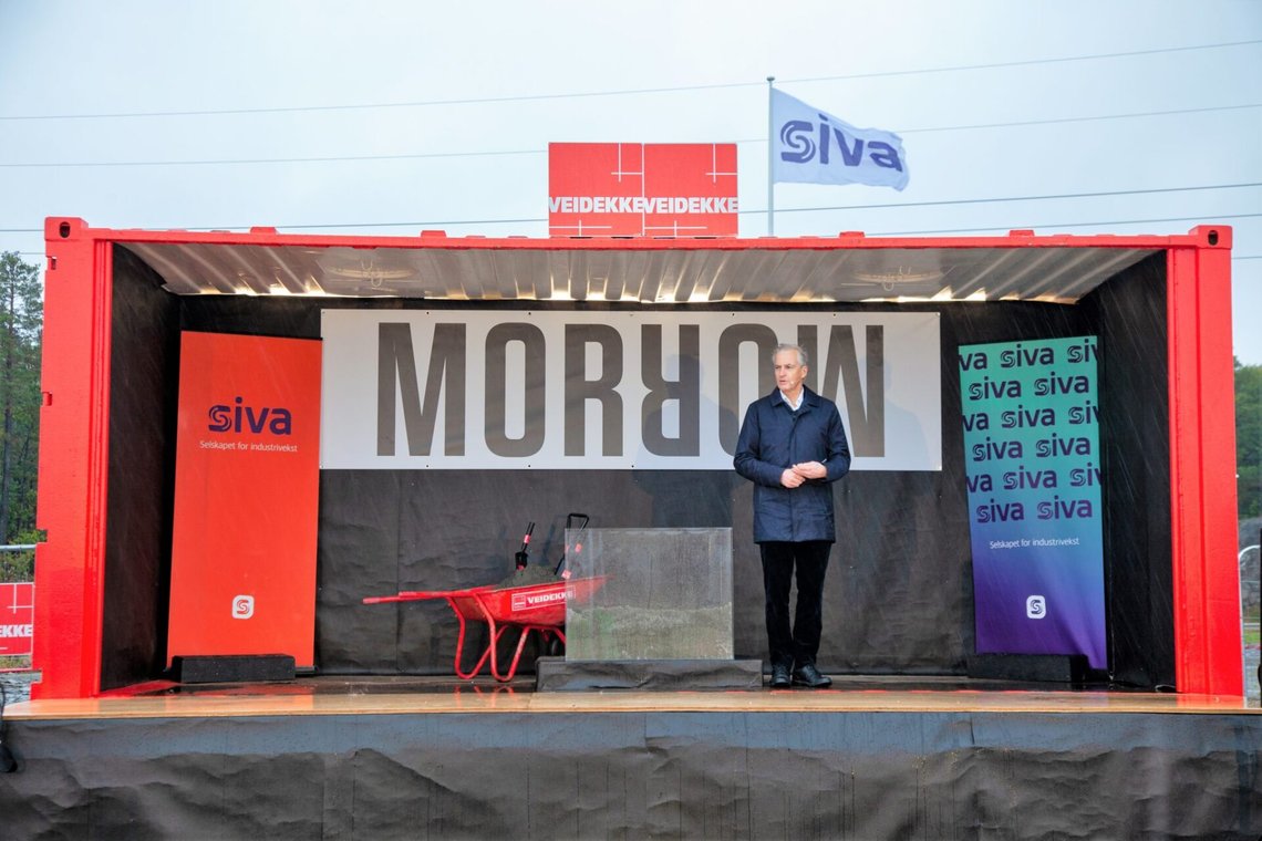 En improviserad scen i klara färger med slogans och symboliska rekvisita, med en lätt desorienterad premiärminister för att lysa upp det hela. "Det gröna skiftet" handlar mycket om bemanning, som med nedläggningen av grundstenen för Morrow Batteries batterifabrik i Arendal den 26 september 2022. Foto: Morrow En improviserad scen i klara färger med slogans och symboliska rekvisita, med en lätt desorienterad premiärminister för att lysa upp det hela. "Det gröna skiftet" handlar mycket om bemanning, som med nedläggningen av grundstenen för Morrow Batteries batterifabrik i Arendal den 26 september 2022. Foto: Morrow