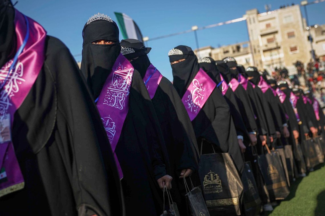 Flickor står under en ceremoni till minne av mer än tusen ungdomar som memorerade Koranen medan de studerade i Dar Al-Wahi-nätverket av religiösa skolor, som drivs under statlig tillsyn, på den kommunala stadion i Idlib, Syrien, 26 april 2025. Foto: Ghaith Alsayed/AP Photo Flickor står under en ceremoni till minne av mer än tusen ungdomar som memorerade Koranen medan de studerade i Dar Al-Wahi-nätverket av religiösa skolor, som drivs under statlig tillsyn, på den kommunala stadion i Idlib, Syrien, 26 april 2025. Foto: Ghaith Alsayed/AP Photo