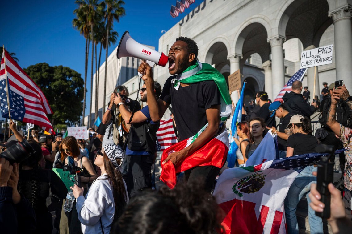 En man ropar in i en megafon utanför stadshuset under protester mot federala immigrationskontroller den 11 juni 2025 i Los Angeles. Foto: Ethan Swope/AP Photo En man ropar in i en megafon utanför stadshuset under protester mot federala immigrationskontroller den 11 juni 2025 i Los Angeles. Foto: Ethan Swope/AP Photo