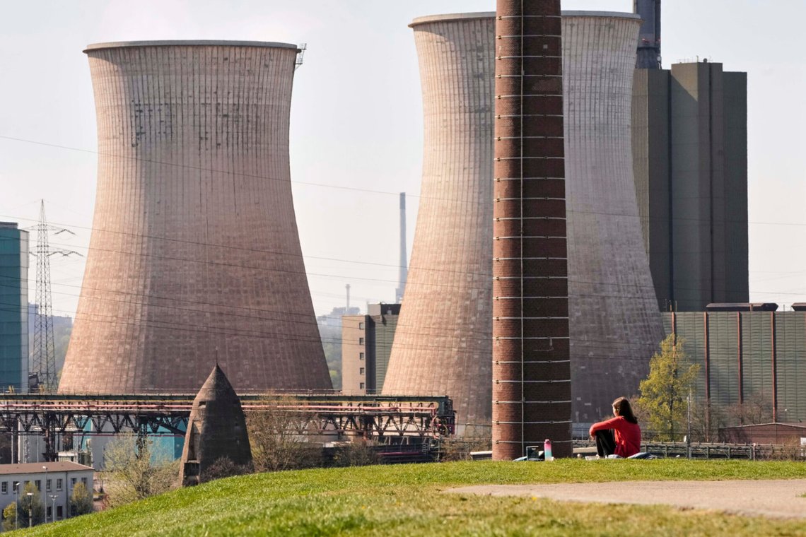 En flicka sitter i gräset inte långt från gaskraftverket vid Krupp Mannesmanns stålproduktionsanläggning i Duisburg den 3 april 2025. Foto: Martin Meissner / AP / NTB. En flicka sitter i gräset inte långt från gaskraftverket vid Krupp Mannesmanns stålproduktionsanläggning i Duisburg den 3 april 2025. Foto: Martin Meissner / AP / NTB.