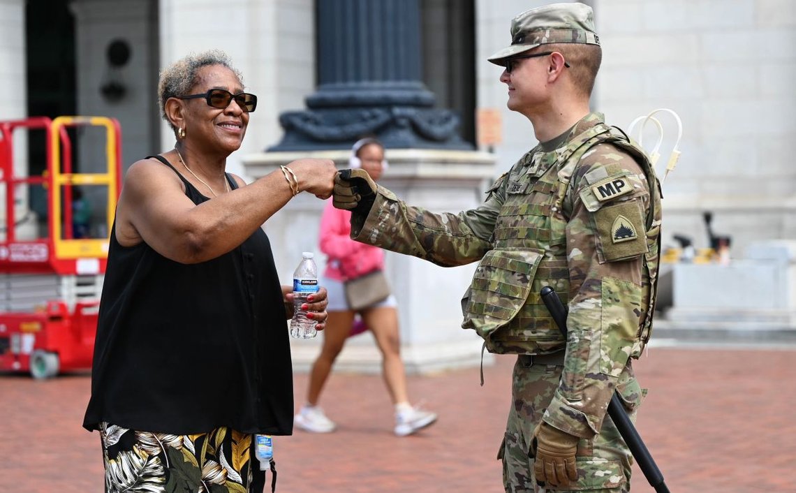 En soldat från District of Columbia National Guard ger en medborgare en "fist bump" utanför Union Station i augusti 2025. Cirka 800 soldater är utplacerade i Washington, D.C. för att tillhandahålla allmän säkerhet och stödja brottsbekämpande myndigheter. Foto: Army Tech Sgt. Andrew Enriquez, Army National Guard. Källa: Försvarsdepartementet. En soldat från District of Columbia National Guard ger en medborgare en "fist bump" utanför Union Station i augusti 2025. Cirka 800 soldater är utplacerade i Washington, D.C. för att tillhandahålla allmän säkerhet och stödja brottsbekämpande myndigheter. Foto: Army Tech Sgt. Andrew Enriquez, Army National Guard. Källa: Försvarsdepartementet.