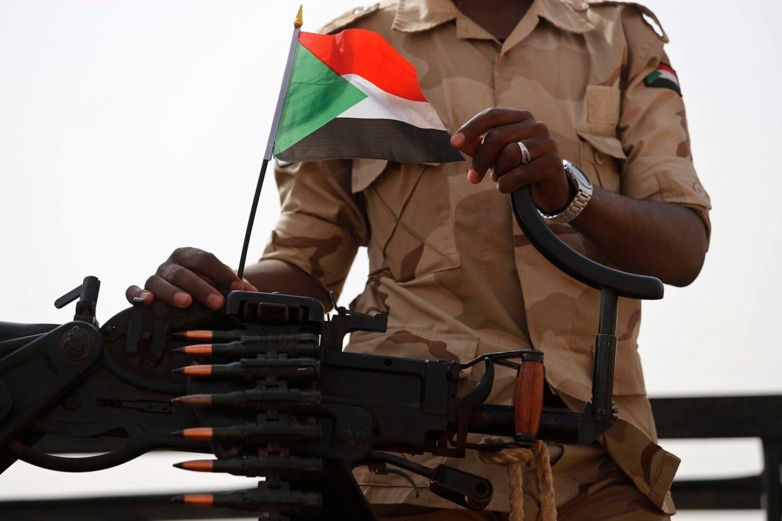 En soldat från Rapid Support Forces (RSF) med den sudanesiska nationella flaggan. Östnilprovinsen, Sudan, juni 2019. Foto: Hussein Malla/AP Photo En soldat från Rapid Support Forces (RSF) med den sudanesiska nationella flaggan. Östnilprovinsen, Sudan, juni 2019. Foto: Hussein Malla/AP Photo