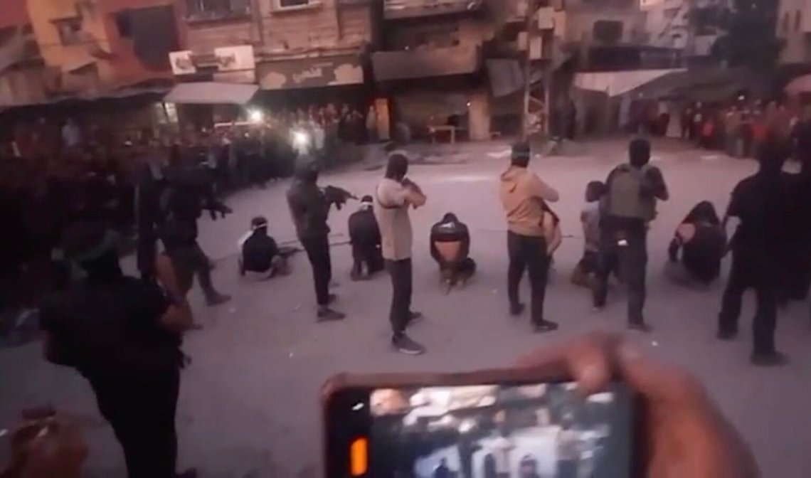 Beväpnade män med gröna pannband av den typ som bärs av Hamasmilitanter förbereder sig för att avrätta åtta personer i Gaza, medan folkmassan på platsen filmar dem med mobiltelefoner och ropar "Allahu akbar!". Foto: Skärmdump av video Reuters / Jerusalem Post. Beväpnade män med gröna pannband av den typ som bärs av Hamasmilitanter förbereder sig för att avrätta åtta personer i Gaza, medan folkmassan på platsen filmar dem med mobiltelefoner och ropar "Allahu akbar!". Foto: Skärmdump av video Reuters / Jerusalem Post.