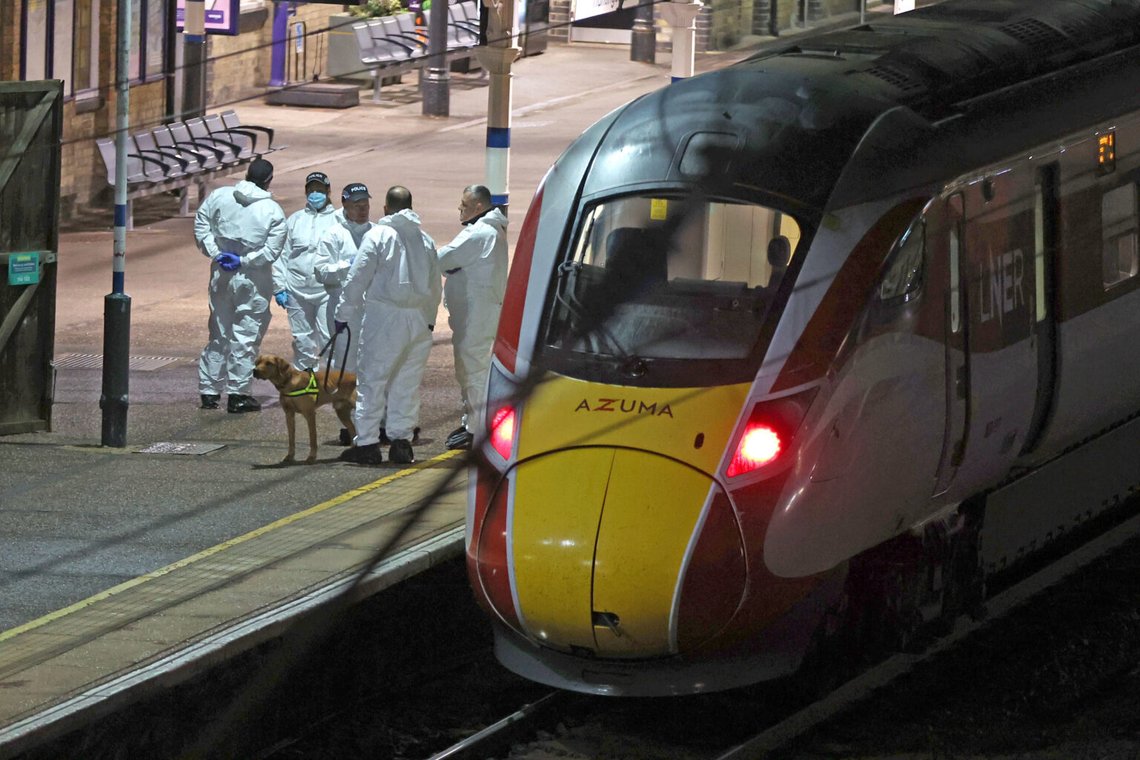 Rättsmedicinare står på perrongen bredvid ett tåg på stationen i Huntongdon, England, efter en knivattack ombord på tåget den 1 november 2025. Foto: Chris Radburn / PA via AP / NTB. Rättsmedicinare står på perrongen bredvid ett tåg på stationen i Huntongdon, England, efter en knivattack ombord på tåget den 1 november 2025. Foto: Chris Radburn / PA via AP / NTB.