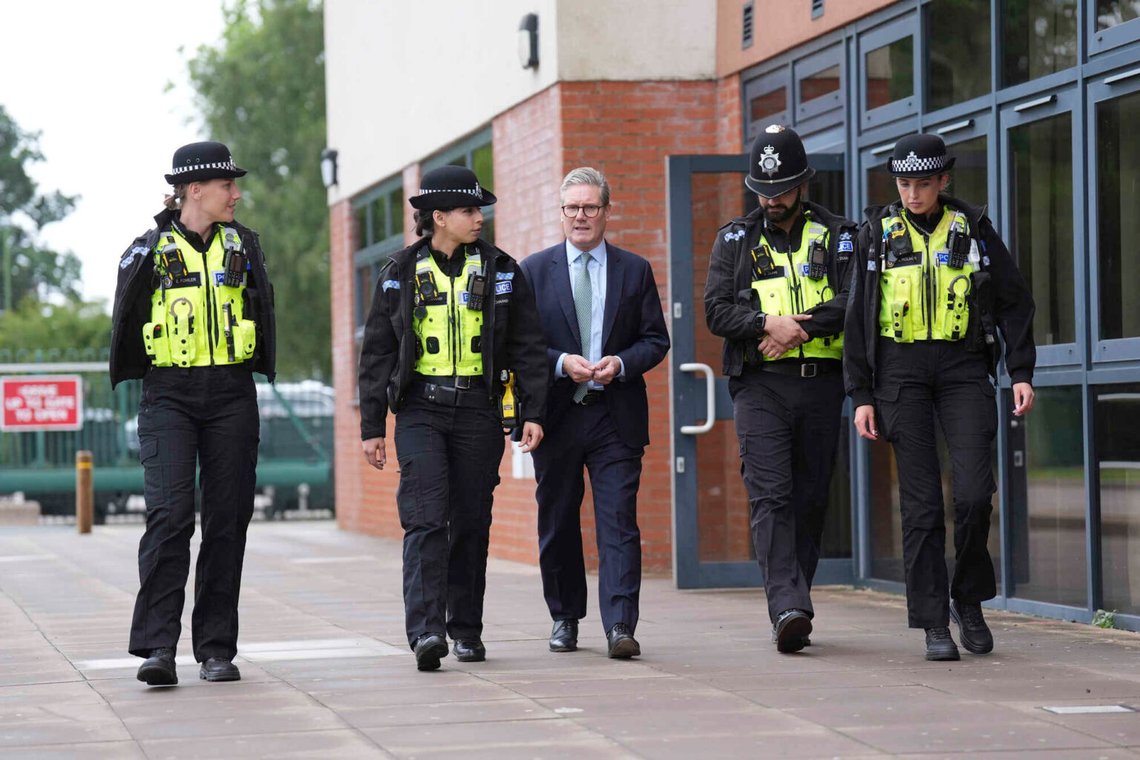 Storbritanniens premiärminister Sir Keir Starmer, i mitten, promenerar med medlemmar av West Midlands polisstyrka vid Arden Academy i Solihull, West Midlands, England, 8 augusti 2024. Foto: Joe Giddens/AP/NTB. Storbritanniens premiärminister Sir Keir Starmer, i mitten, promenerar med medlemmar av West Midlands polisstyrka vid Arden Academy i Solihull, West Midlands, England, 8 augusti 2024. Foto: Joe Giddens/AP/NTB.
