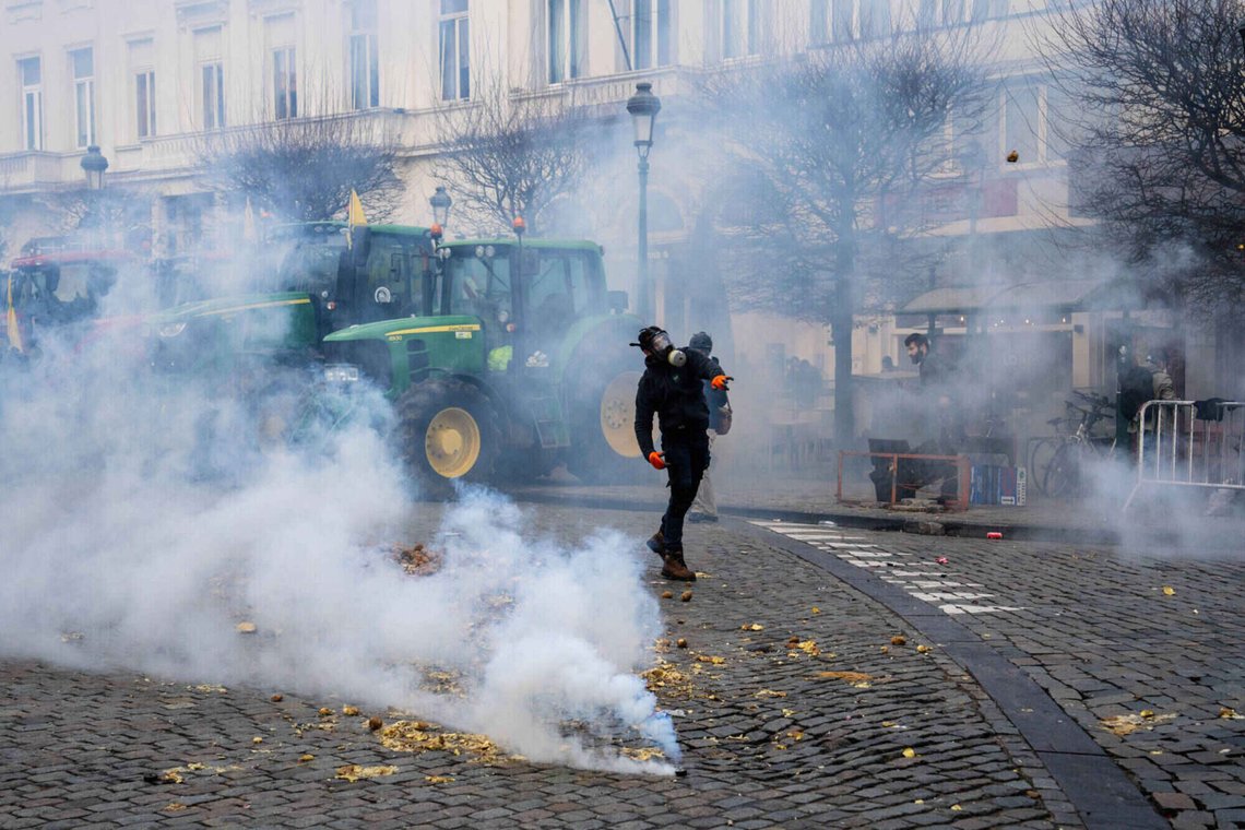 En rasande bonde kastar potatis mot polisen i Bryssel, som svarar med tårgas. Foto: Marius Burgelman/ AP/ NTB En rasande bonde kastar potatis mot polisen i Bryssel, som svarar med tårgas. Foto: Marius Burgelman/ AP/ NTB