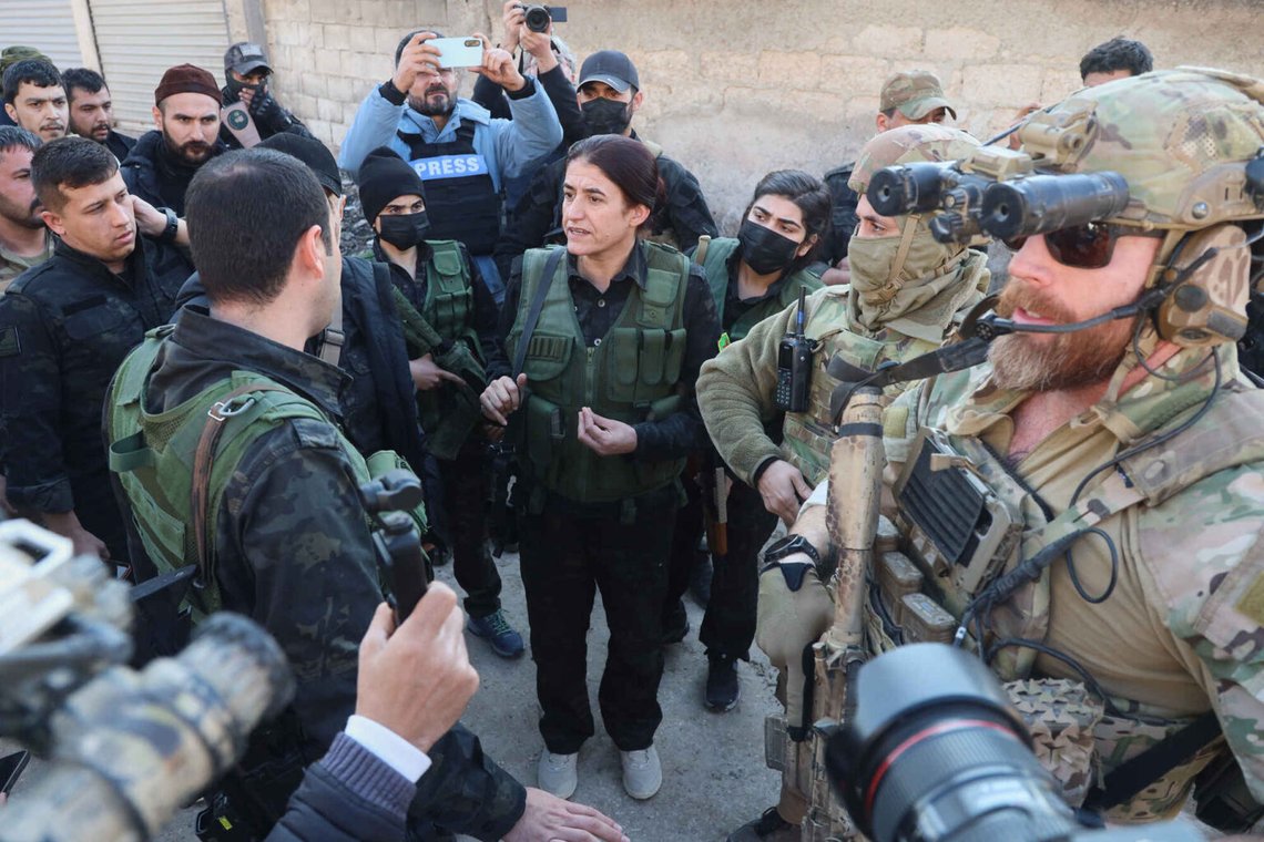 Rohlat Efrin, center, en befälhavare i de USA-stödda syriska demokratiska styrkorna, talar med en SDF-medlem när amerikanska soldater från den USA-ledda koalitionen mot gruppen Islamiska staten står vakt under ett möte i Deir Hafer, Syrien, fredagen den 16 januari 2026. Foto: Baderkhan Ahmad/ AP Photo Rohlat Efrin, center, en befälhavare i de USA-stödda syriska demokratiska styrkorna, talar med en SDF-medlem när amerikanska soldater från den USA-ledda koalitionen mot gruppen Islamiska staten står vakt under ett möte i Deir Hafer, Syrien, fredagen den 16 januari 2026. Foto: Baderkhan Ahmad/ AP Photo