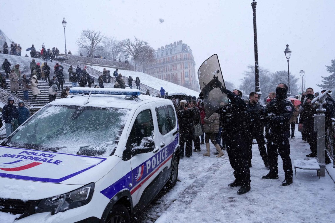 En polis använder sin sköld för att undvika en snöboll under ett snöfall i Montmartre-distriktet, 5 januari 2026 i Paris. Foto: Aurelien Morissard/AP-NTB. En polis använder sin sköld för att undvika en snöboll under ett snöfall i Montmartre-distriktet, 5 januari 2026 i Paris. Foto: Aurelien Morissard/AP-NTB.