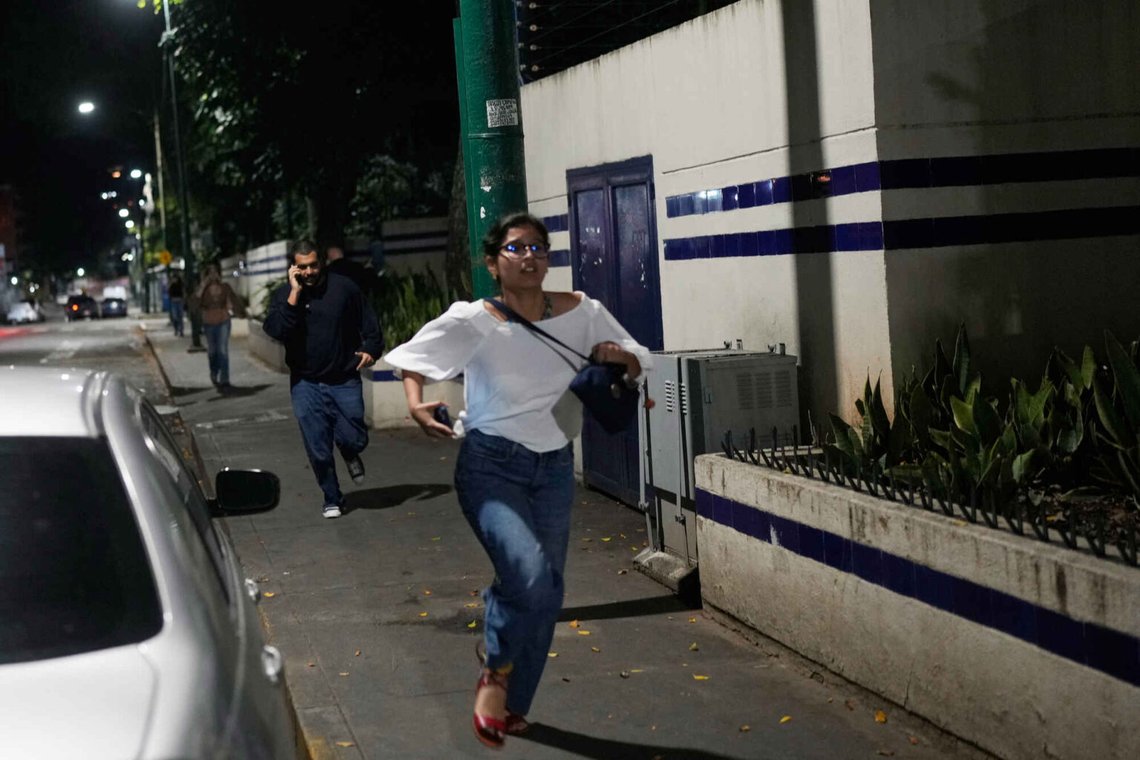 Fotgängare springer i Caracas medan ljudet av explosioner ekade genom staden tidigt på lördagsmorgonen. Foto: Matias Delacroix / AP / NTB Fotgängare springer i Caracas medan ljudet av explosioner ekade genom staden tidigt på lördagsmorgonen. Foto: Matias Delacroix / AP / NTB