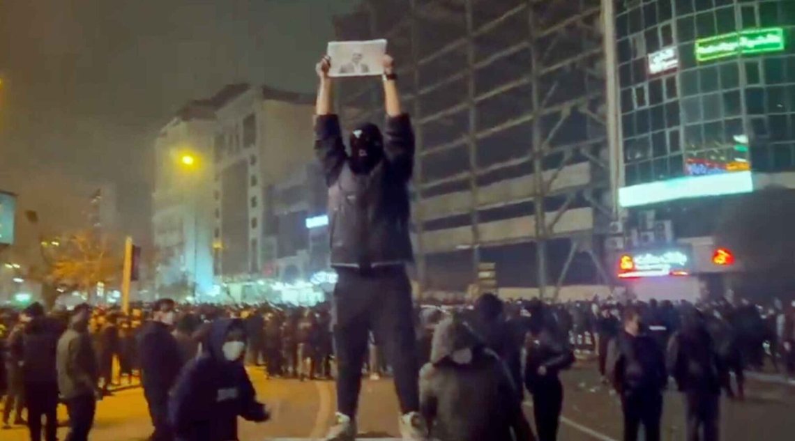 En maskerad demonstrant håller upp en bild av shahens son Reza Pahlavi under en protest i Teheran den 9 januari 2025. Foto: UGC via AP / NTB. En maskerad demonstrant håller upp en bild av shahens son Reza Pahlavi under en protest i Teheran den 9 januari 2025. Foto: UGC via AP / NTB.