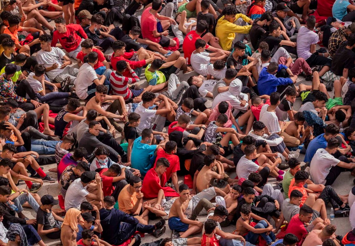 Påstådda minderåriga migranter som har kommit in i den spanska enklaven Ceuta som gränsar till Marocko sitter utanför ett tillfälligt härbärge den 19 maj 2021. Spaniens högsta domstol hade nyligen beslutat att spanska myndigheter agerade olagligt när de skickade ensamkommande minderåriga migranter tillbaka till Marocko 2021. Foto: Bernat Armangue / AP / NTB. Påstådda minderåriga migranter som har kommit in i den spanska enklaven Ceuta som gränsar till Marocko sitter utanför ett tillfälligt härbärge den 19 maj 2021. Spaniens högsta domstol hade nyligen beslutat att spanska myndigheter agerade olagligt när de skickade ensamkommande minderåriga migranter tillbaka till Marocko 2021. Foto: Bernat Armangue / AP / NTB.