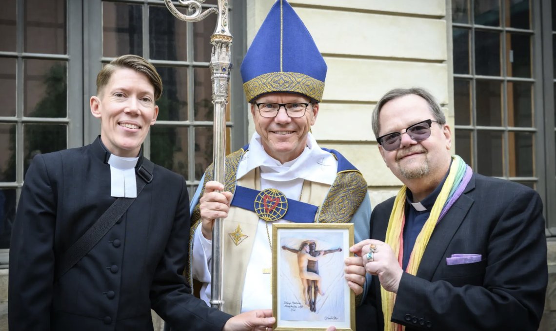 Prästerna Adrienne Riddez och Lars Gårdfeldt lämnar över ett foto homosex till biskop Andreas Holmberg, som tack för biskopens tydliga exkludering. Foto: Skärmdump Facebook (beskuren) Prästerna Adrienne Riddez och Lars Gårdfeldt lämnar över ett foto homosex till biskop Andreas Holmberg, som tack för biskopens tydliga exkludering. Foto: Skärmdump Facebook (beskuren)